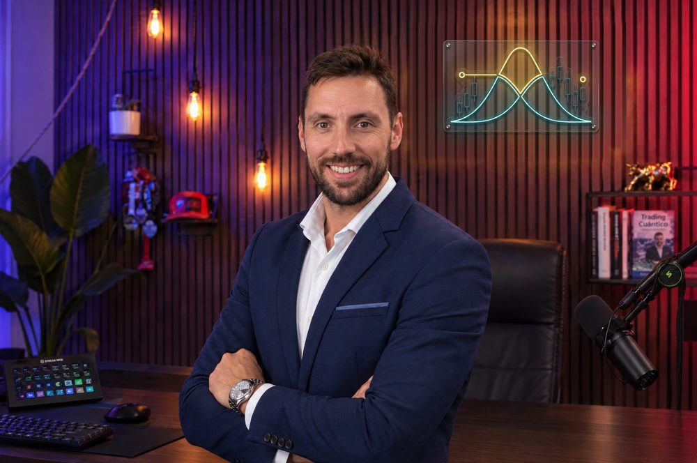 Aleix Fayos, formador de opciones financieras, en su estudio de Campus Opciones con el logo en neón al fondo